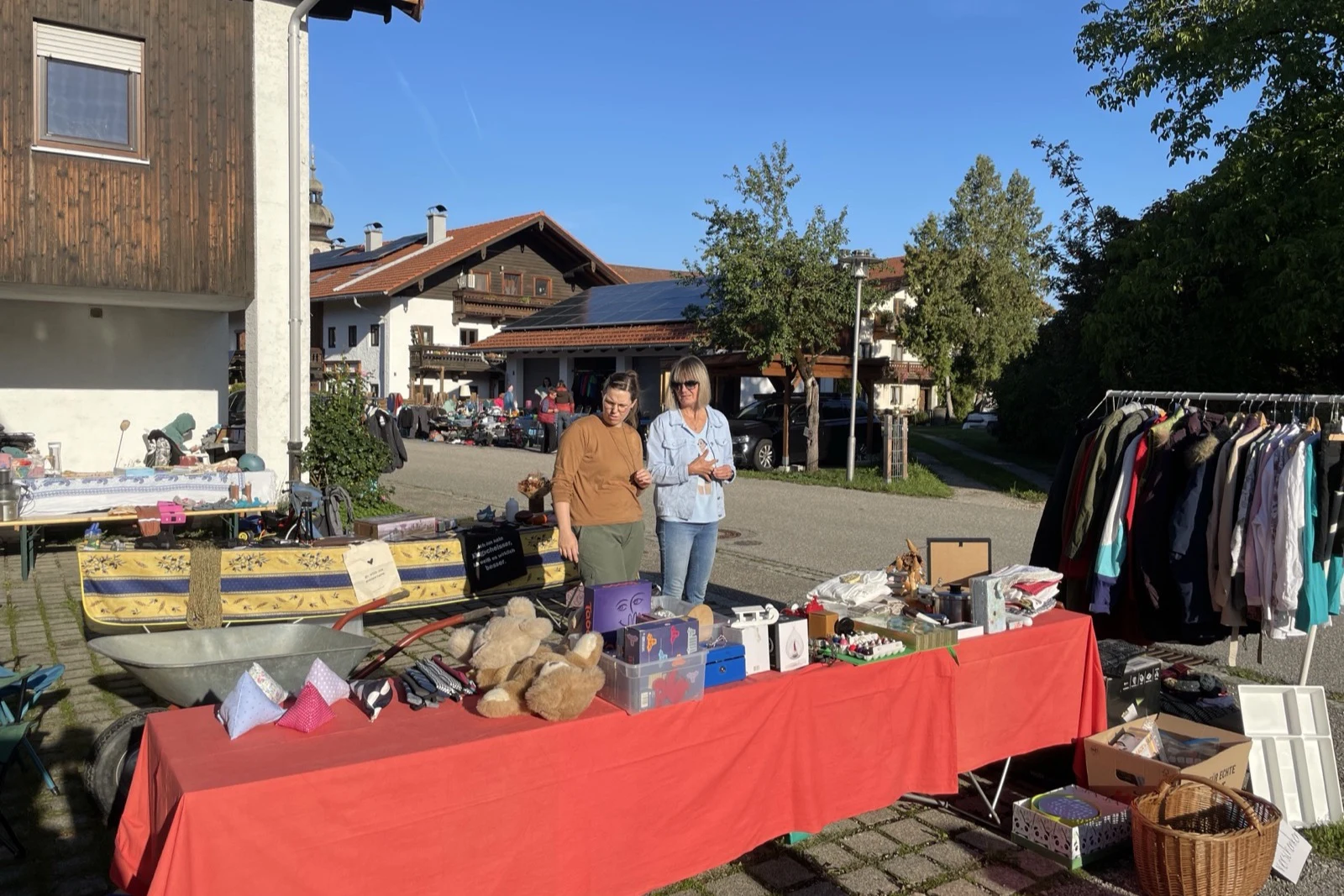 Flohmarktstand mit Kleidung und Fundstücken vor einem Haus in der Siegsdorfer Straße.