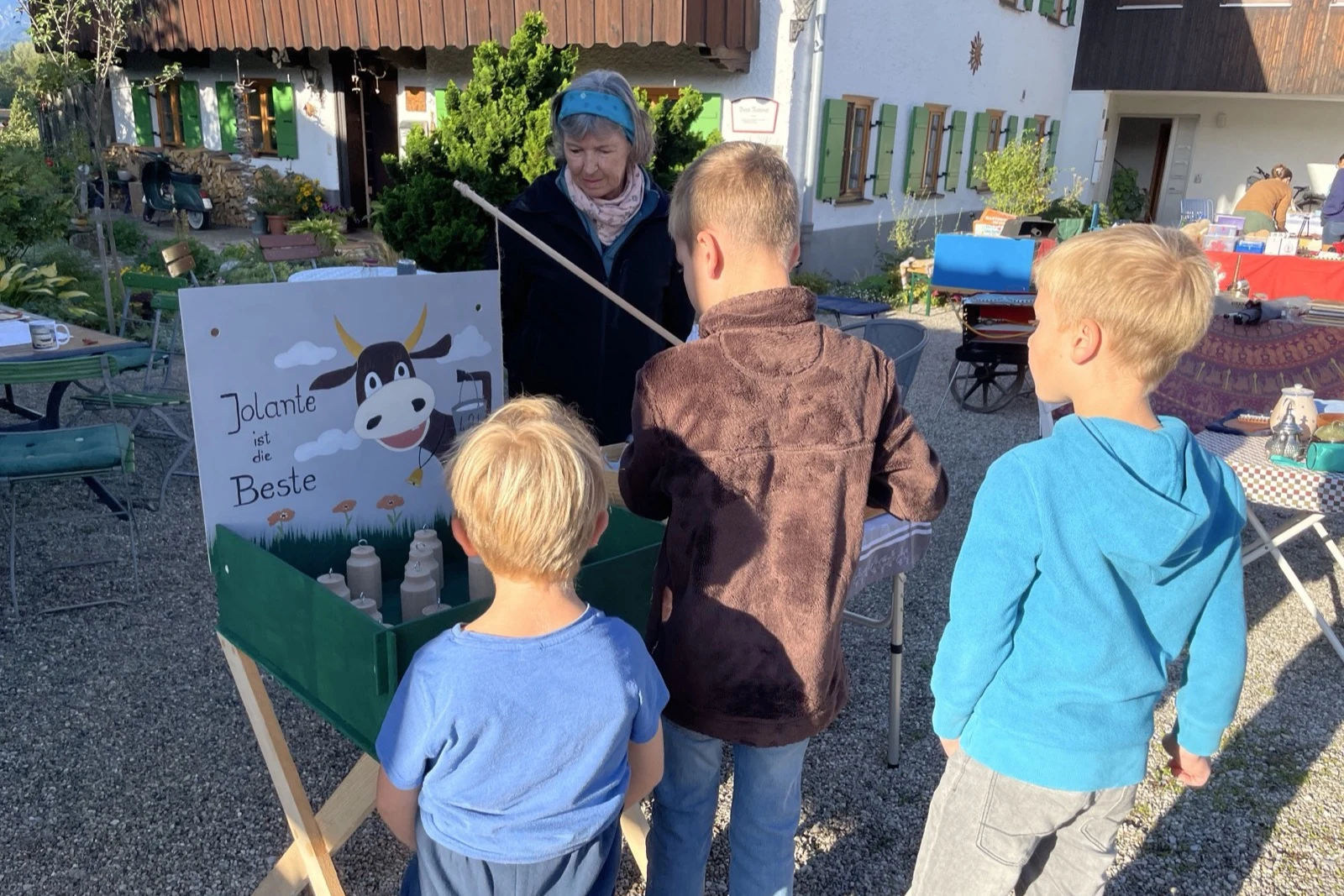 Kinder nehmen am Holzspiel Melk die Kuh teil.