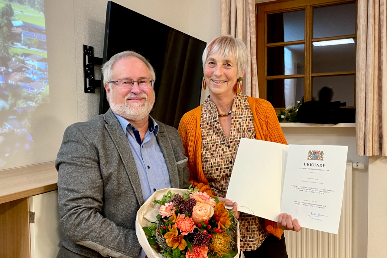 Rainer Schroll überreicht Marlies Kruse Blumen und eine Urkunde