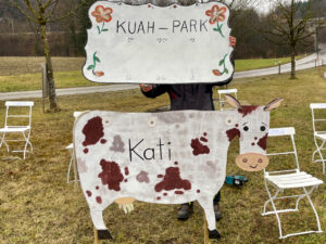 Handgemaltes Kuah-Park-Schild und Kuhfigur an der Siegsdorfer Straße