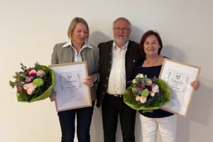 Agnes Göhle und Maria Srkal stehen mit Urkunden und Blumen neben Bürgermeister Rainer Schroll