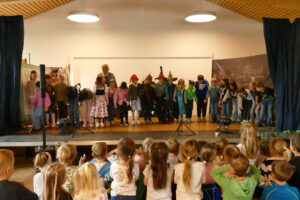 Aufführung der dritten Klasse auf der Bühne im Haus der Dorfgemeinschaft