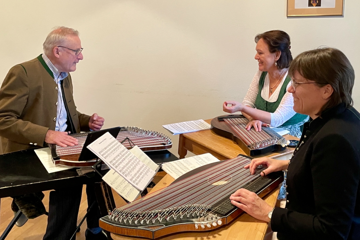Drei Musikerinnen und Musiker mit Zither und Gitarre