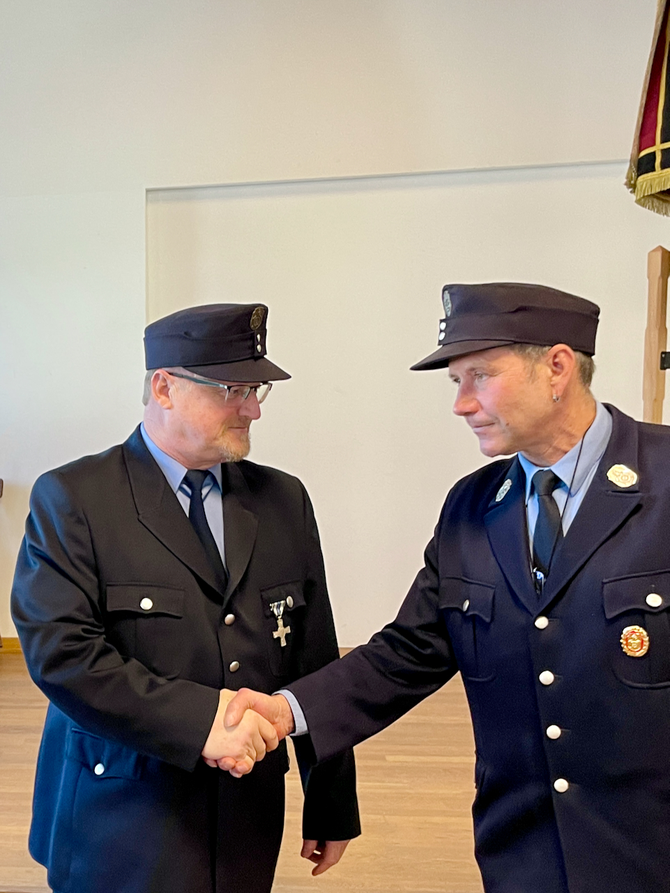 Zwei Feuerwehrmänner reichen sich die Hand
