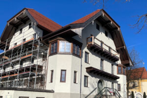 Eingerüsteter Gasthof zur Post bei blauem Himmel