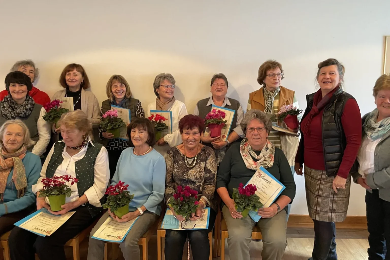 Mitglieder der Frauengemeinschaft Vachendorf bei einer Ehrung mit Blumen und Urkunden.