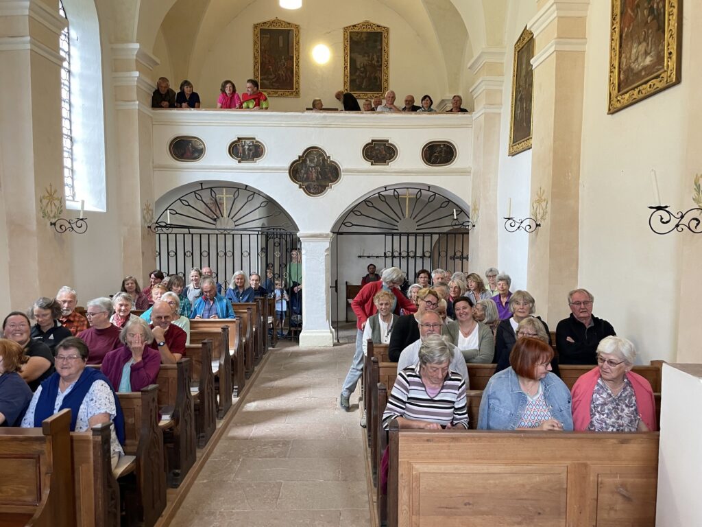 Besucherinnen und Besucher füllen die Kirchenbänke und die Empore von St. Georg am Berg.