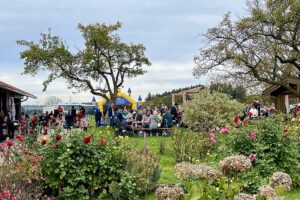 Blick über den Bauerngarten auf das gut besuchte Kirtahutschn in Einharting.