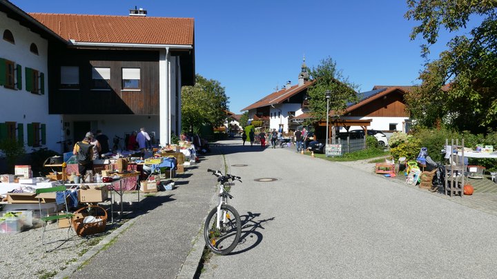 Marktstände entlang der Siegsdorfer Straße, mit Besuchern und Dorfkulisse.