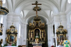 Innenraum der Pfarrkirche Mariä Himmelfahrt in Vachendorf mit Hochaltar und Seitenaltären.