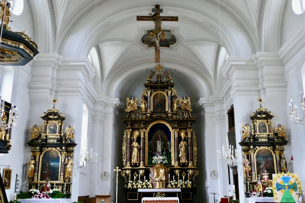Innenraum der Pfarrkirche Mariä Himmelfahrt in Vachendorf mit Hochaltar und Seitenaltären.