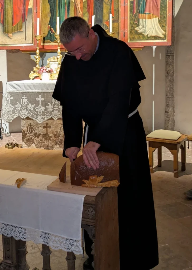 Pater Ioan schneidet zum Abschluss der Erntedankfeier in St. Jakobus Bernhaupten den Brotlaib an.