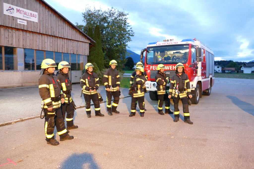Die Gruppe der Feuerwehr Vachendorf steht in Schutzkleidung vor dem Löschfahrzeug.