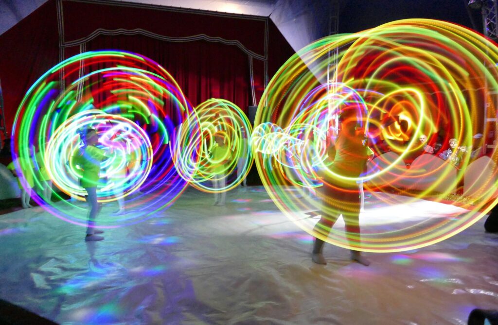 Leuchtende Reifen zeichnen bunte Kreise in die Manege.